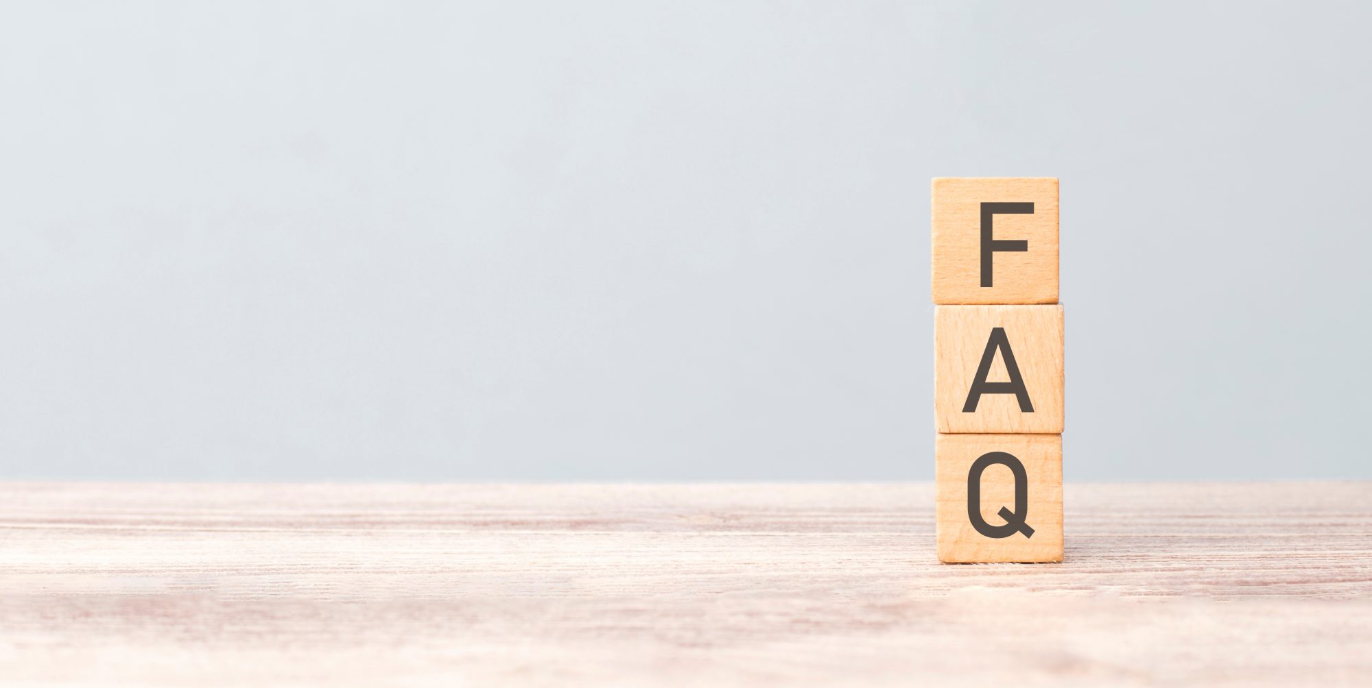 Holzwürfel mit den Buchstaben FAQ – Symbolbild für häufig gestellte Fragen