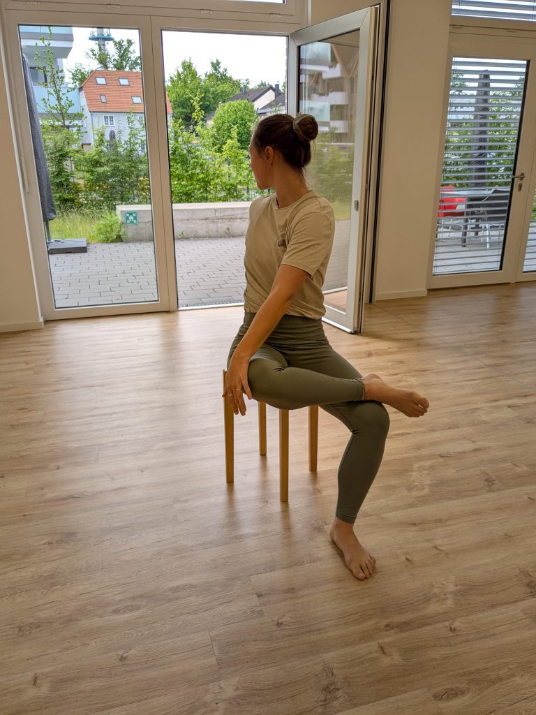 Helena Gnaase zeigt sanfte Drehung im Hocker-Yoga-Kurs im Begegnungszentrum beim DRK Hövelhof