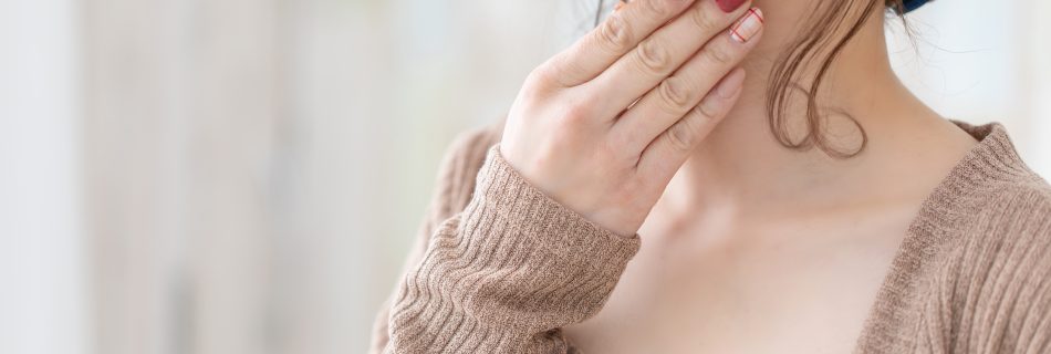 Frau berührt sanft ihren Hals – Symbol für Körperwahrnehmung, Selbstfürsorge und Vagusnerv-Aktivierung durch achtsame Berührung.