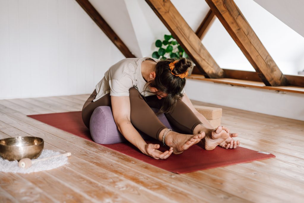 Helena Gnaase praktiziert Yin Yoga mit Bolster und Klötzen – entspannte Haltung am Boden.
